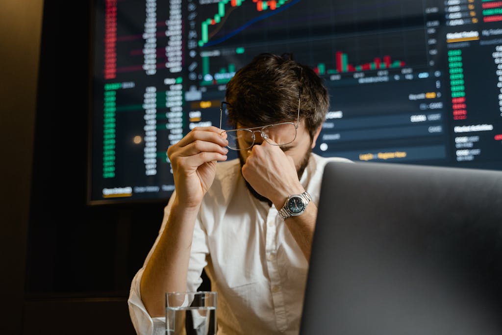 The Hidden Reasons Smart Investors Lose Money: 5 Behavioral Traps A stressed man looks at stock market data on his computer screen in an office setting.
